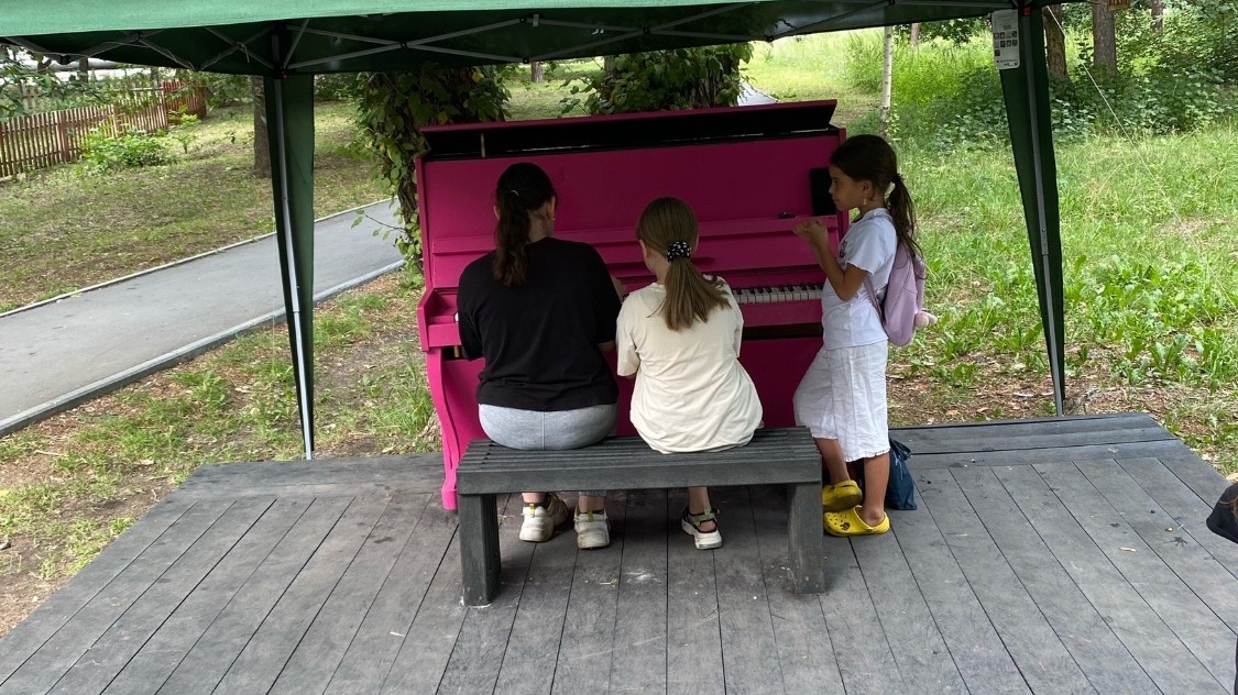Дети увлеченно играют на пианино в Саду Победы