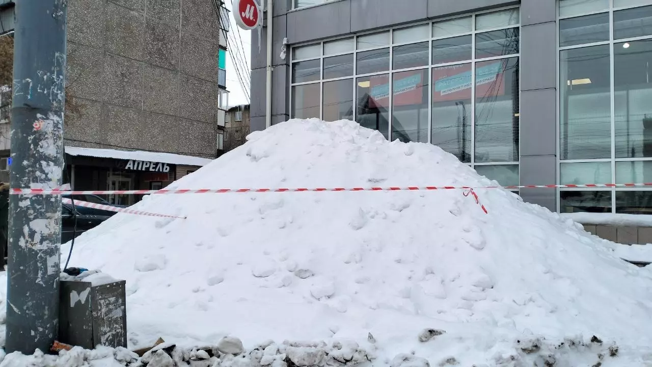 Куча снега возле магазина «М видео», разместившегося в пристрое к зданию гостиницы «Челябинск»