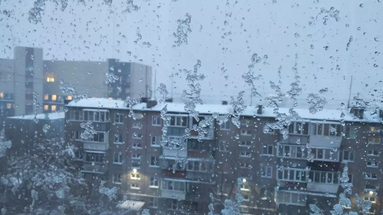 Снег липнет на стекла квартир