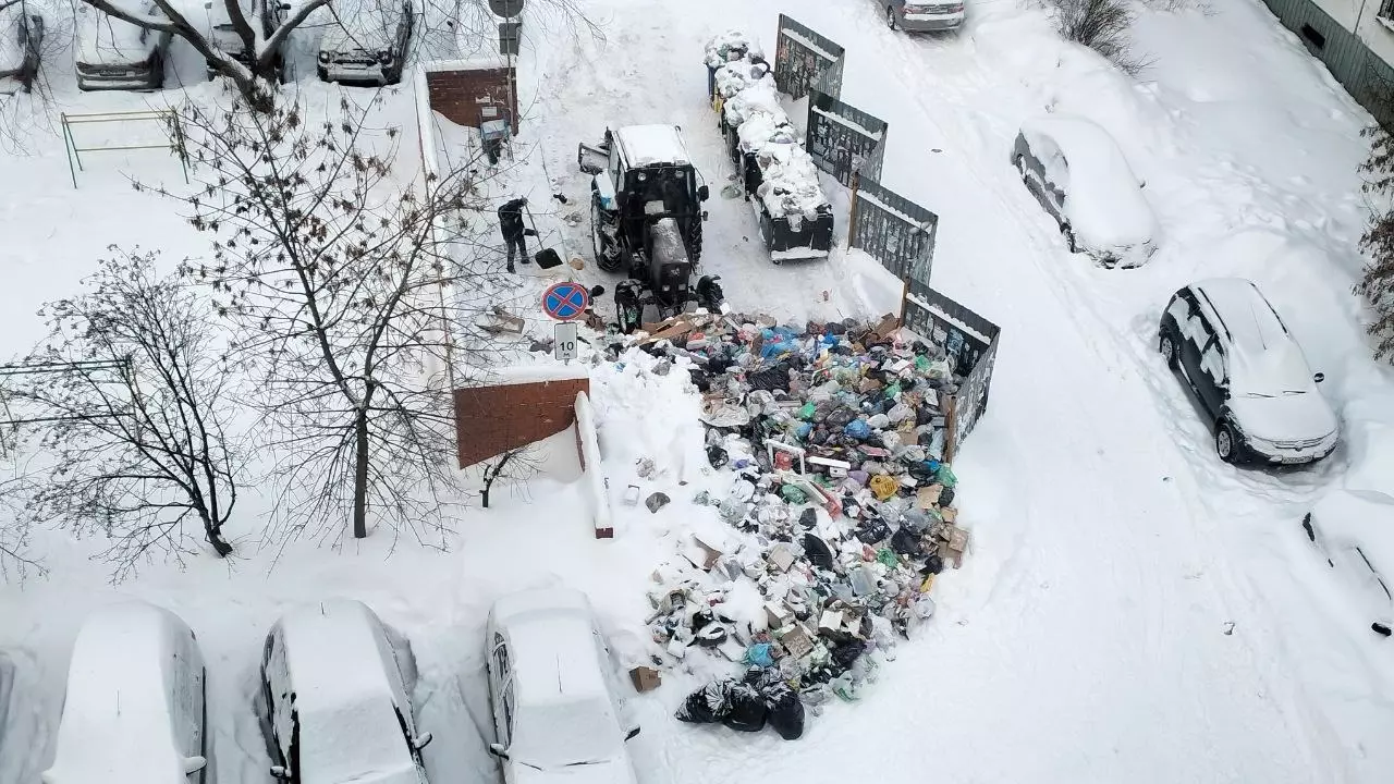 Трактор в Челябинске сдвигает мусорную кучу с контейнерной площадки