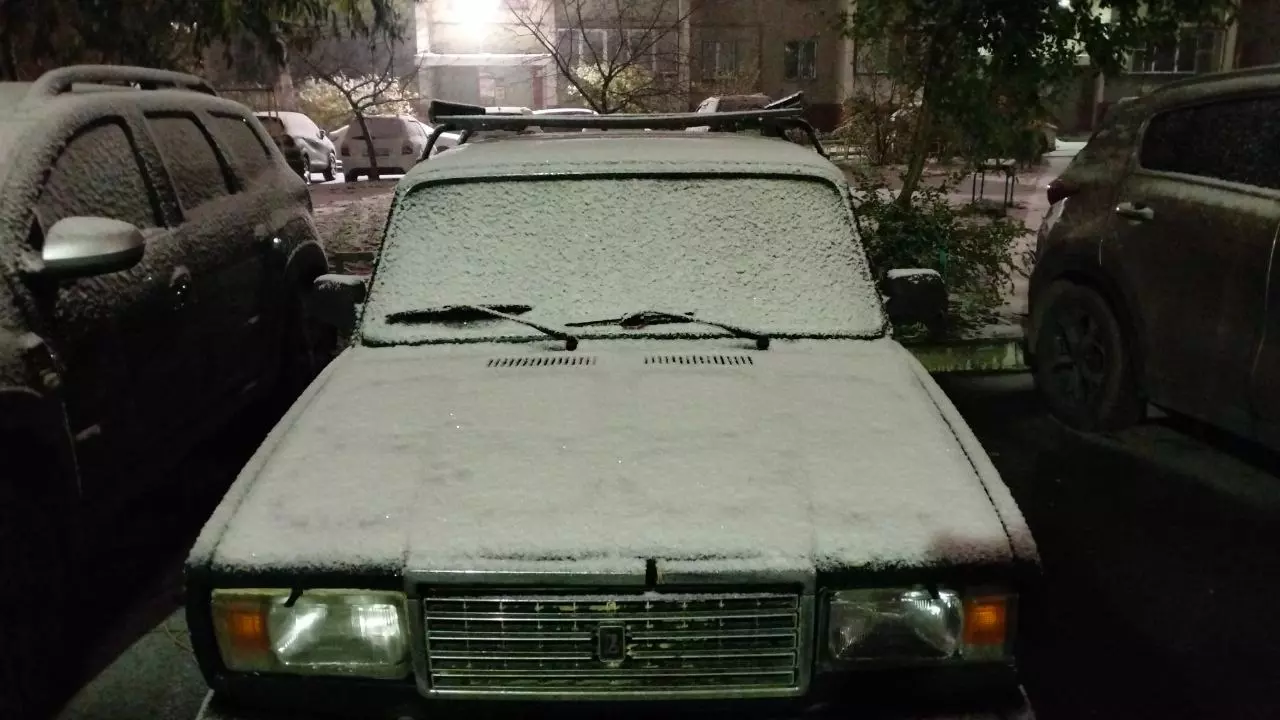 Машины покрыты тонким слоем снега